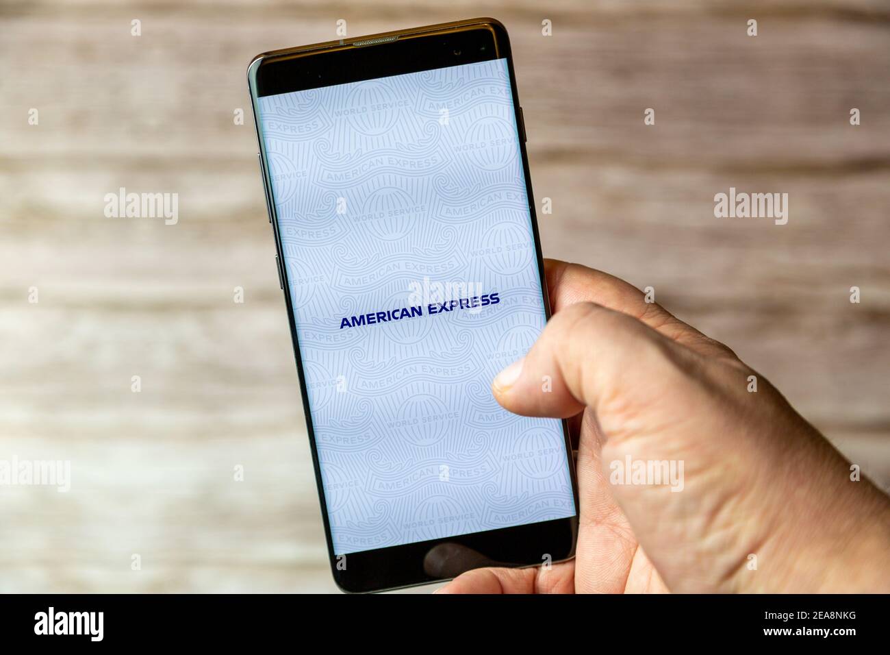 Ein Mobiltelefon oder Mobiltelefon, das in einem gehalten wird Hand mit der American Express App geöffnet auf dem Bildschirm Stockfoto
