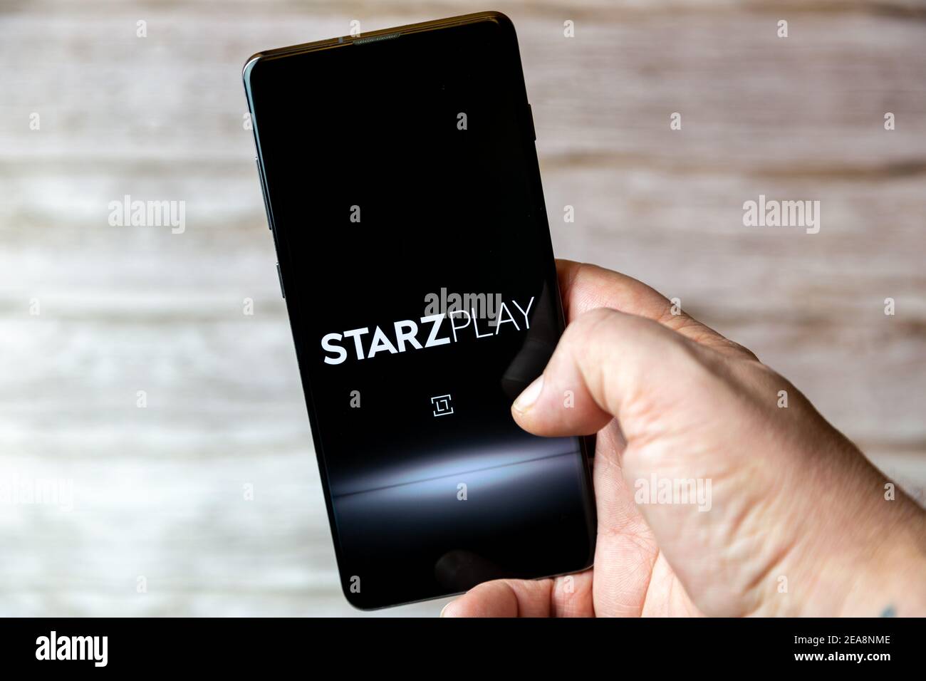 Ein Mobiltelefon oder Mobiltelefon, das in einem gehalten wird Hand mit der Starzplay TV App geöffnet auf dem Bildschirm Stockfoto