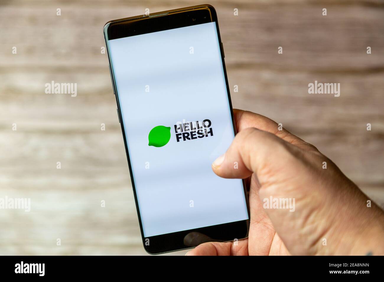 Ein Mobiltelefon oder Mobiltelefon, das in einem gehalten wird Hand mit der Hello Fresh App auf dem Bildschirm geöffnet Stockfoto