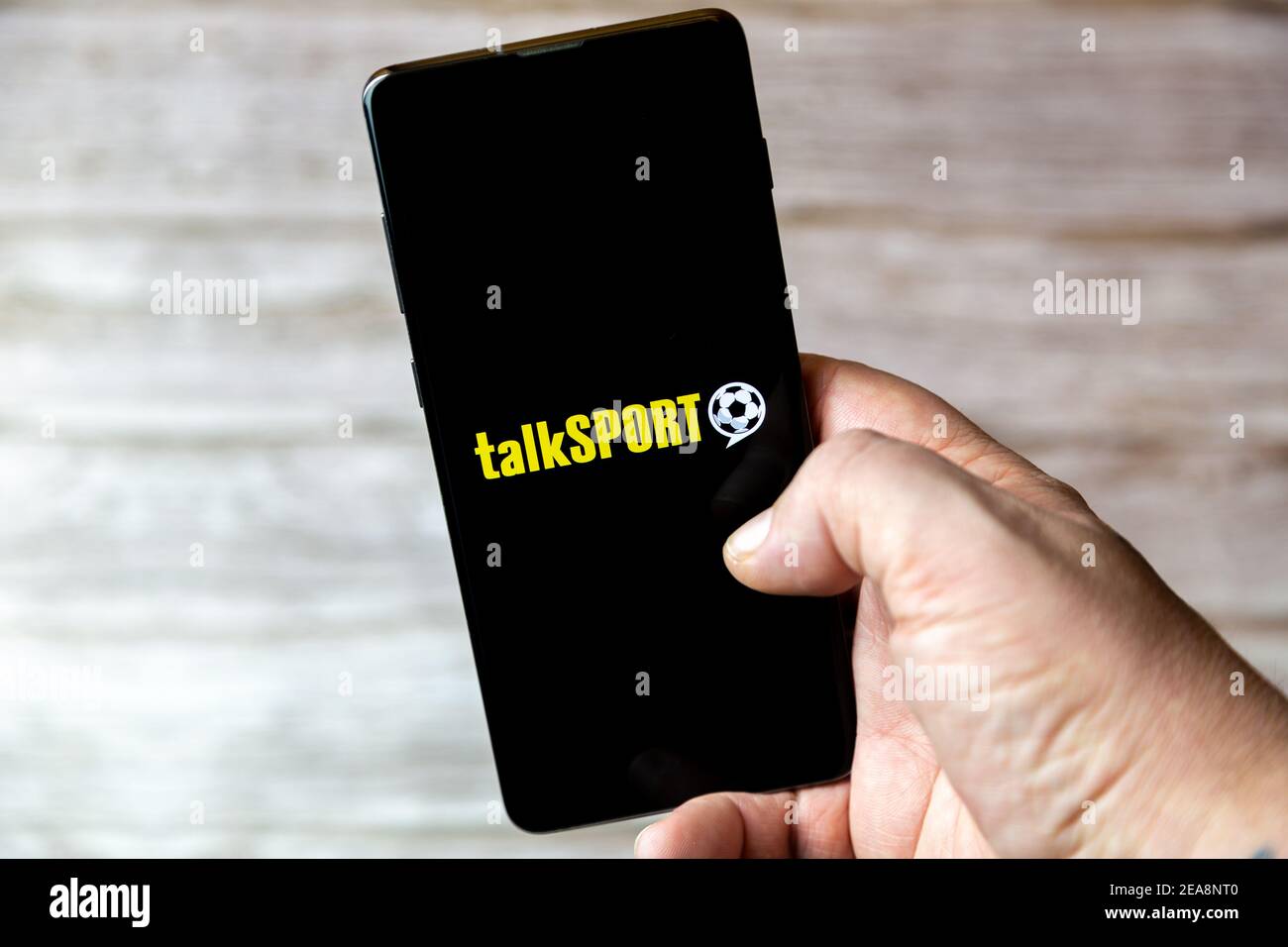 Ein Mobiltelefon oder Mobiltelefon, das in einem gehalten wird Hand mit der Talk Sport Radio App auf dem Bildschirm geöffnet Stockfoto
