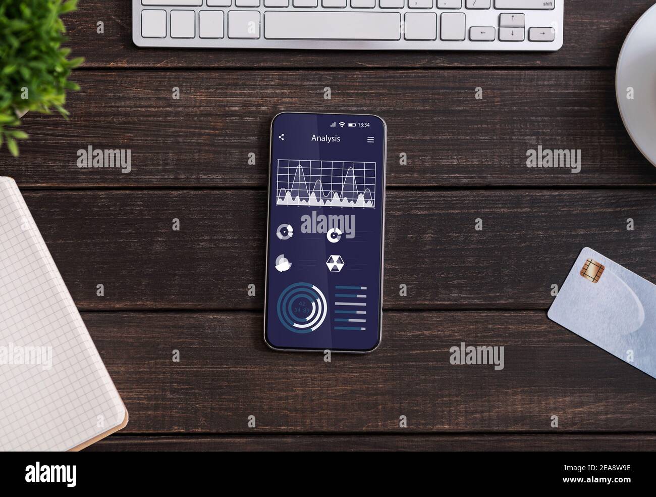 Smartphone mit Business Analytics auf dem Bildschirm flach auf dem Tisch liegen Im Büro Stockfoto