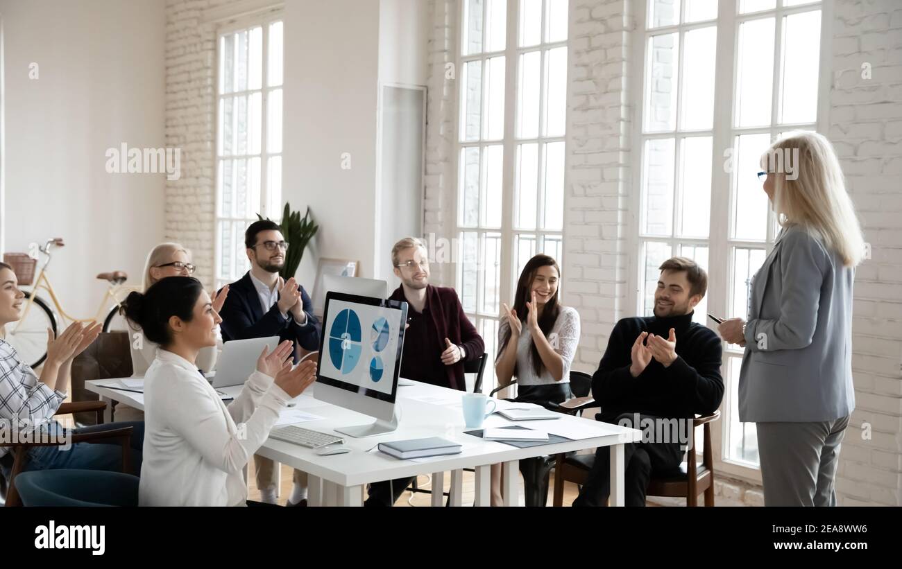 Vielfältiges, tausendjähriges Geschäftsteam, das sich bei der Trainerin bedankt Stockfoto