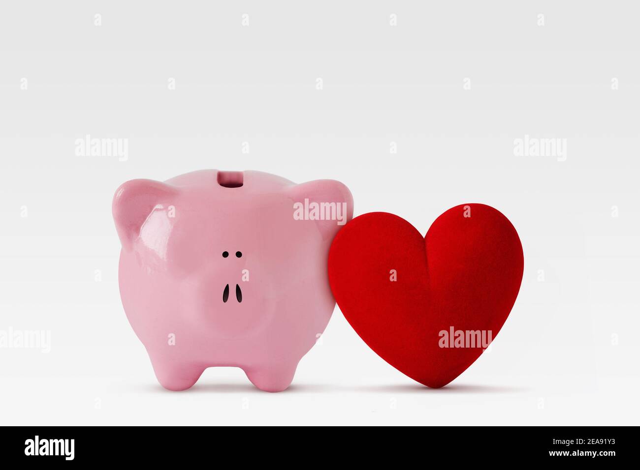 Sparschwein mit Herz auf weißem Hintergrund - Konzept Liebe und Geld Stockfoto