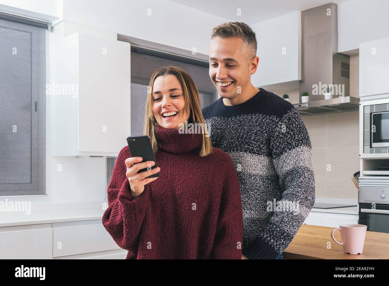 Junges Paar, Mann und Frau haben eine tolle Zeit zusammen suchen ein Handy in der Wohnung. Paar Leben zu Hause Konzept Stockfoto