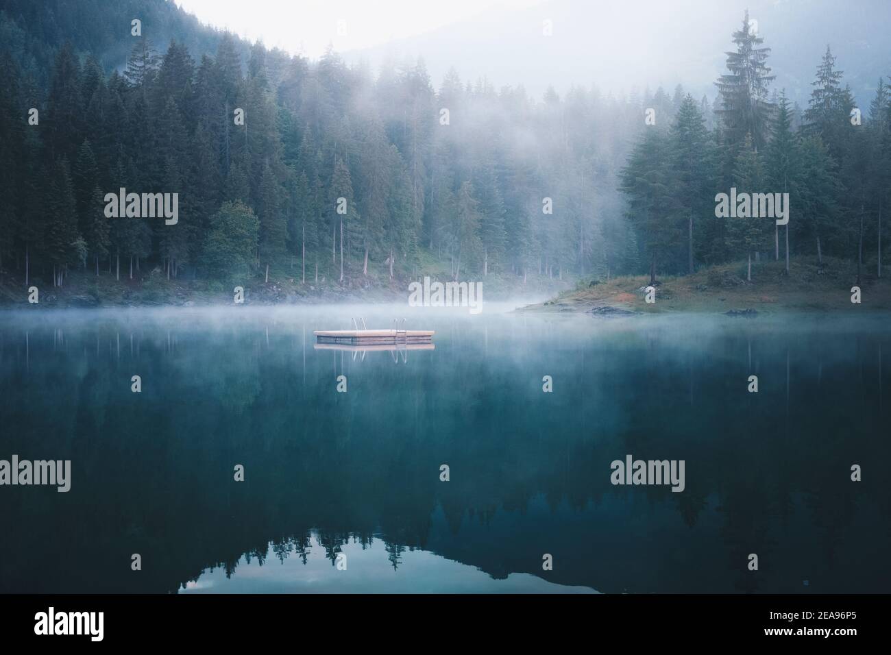 Lake Cauma im nebligen Sonnenaufgang. Die Landschaft spiegelt sich im See wider Stockfoto