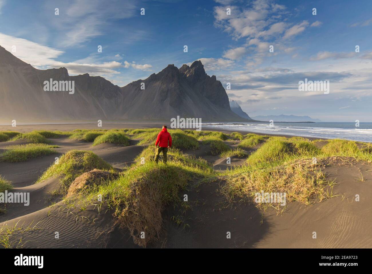 Wanderer mit Blick auf das Vestrahorn / Vesturhorn, aus Gabbro- und Granophyre-Felsen, Teil des Klifatindur-Gebirges bei Stokksnes, Island Stockfoto