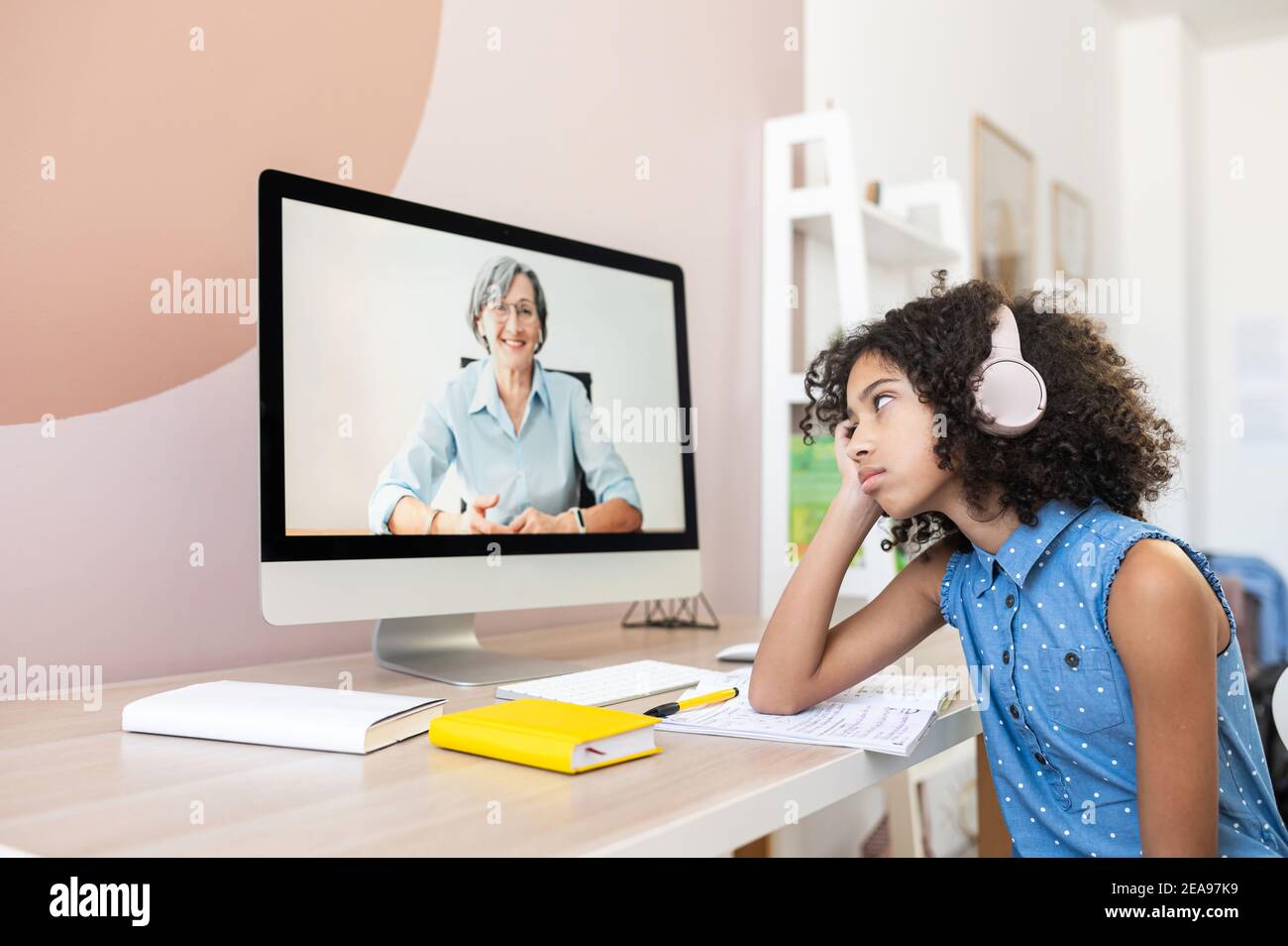 Ein Porträt von gelangweilten afrikanischen Mädchen homeschooling mit Online-Lehrer. Ein Schulmädchen fühlt sich von monotonen Lektionen und vielen Hausaufgaben müde Stockfoto