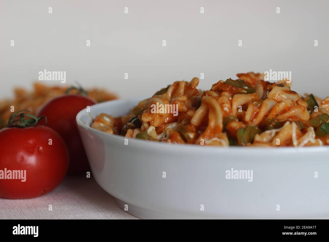 Rote Sauce Pasta mit Paprika. Hausgemachte Fusilli Pasta mit Arrabbiata Sauce. Fotografiert auf weißem Hintergrund. Stockfoto