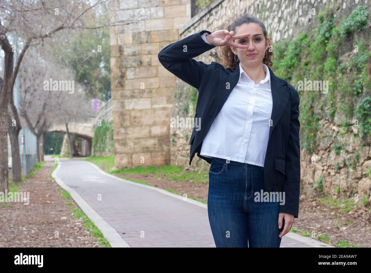Schöne Geschäftsfrau tut das Frieden / Sieg Zeichen im Freien Stockfoto