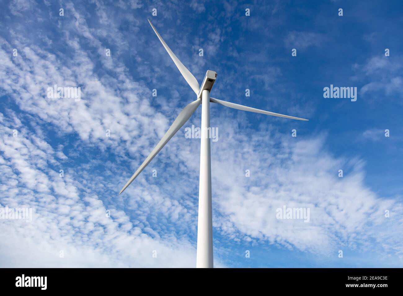 Windturbine auf blauem bewölktem Himmel Hintergrund, Luftdrohne Ansicht, Alternative Energieerzeugung Konzept, Grüne Öko erneuerbare Industrie Stockfoto