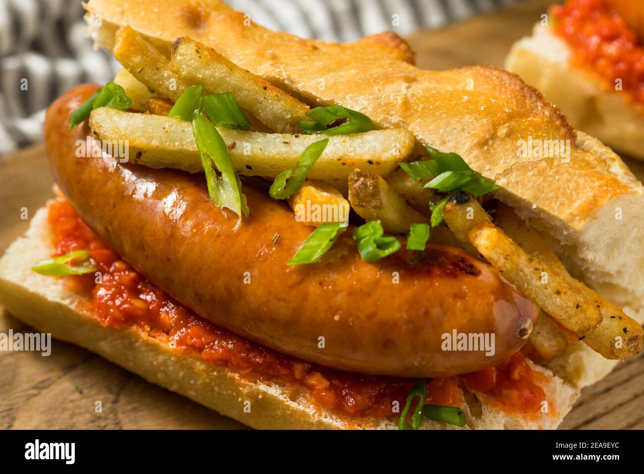 Hausgemachtes Merguez Frites Sausage Sandwich mit Harrisa auf einem Brötchen Stockfoto