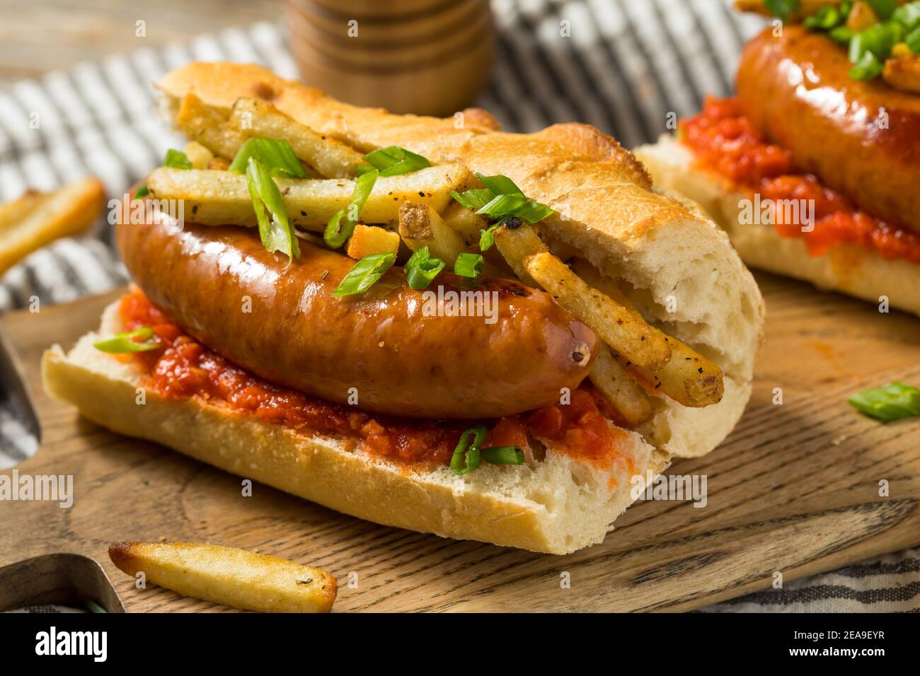 Hausgemachtes Merguez Frites Sausage Sandwich mit Harrisa auf einem Brötchen Stockfoto