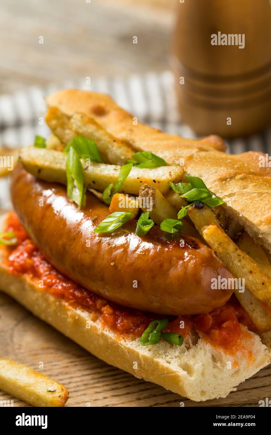 Hausgemachtes Merguez Frites Sausage Sandwich mit Harrisa auf einem Brötchen Stockfoto