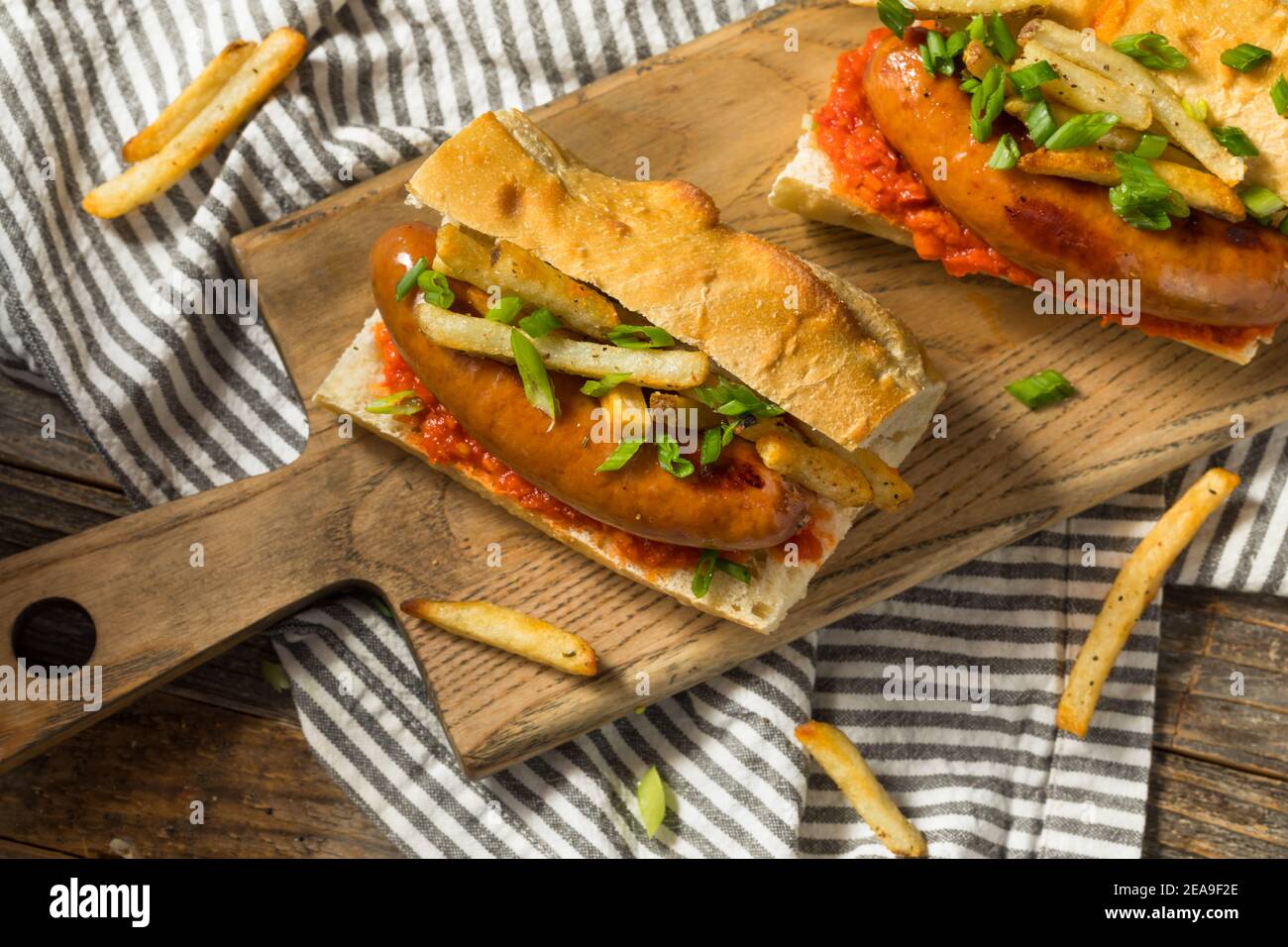 Hausgemachtes Merguez Frites Sausage Sandwich mit Harrisa auf einem Brötchen Stockfoto