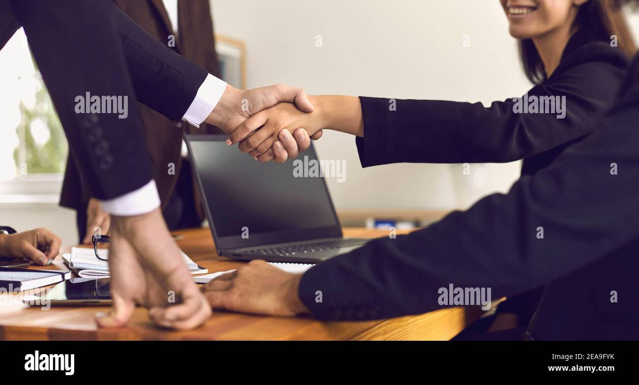 Geschäftsleute, die einen erfolgreichen Abschluss machen und die Zusammenarbeit durch Händeschütteln bestätigen Stockfoto