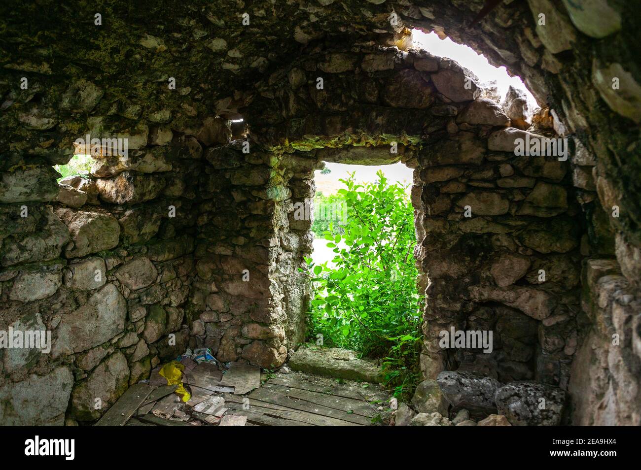 Ruinen einer Berghütte, die jetzt von der Natur verschlungen ist. Stockfoto