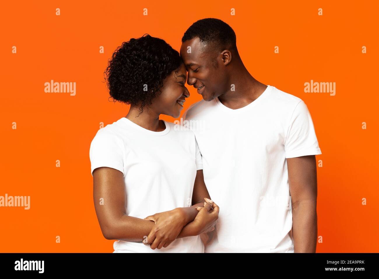 Nahaufnahme von liebevollen schwarzen Paar Bindung auf orange Stockfoto
