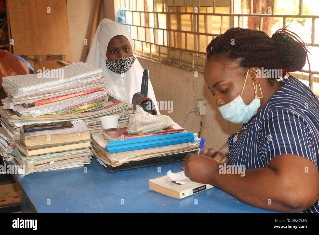 Ein Schüler und ein Lehrer in einem Klassenzimmer. Die Schulen in Nigeria haben angesichts der Angst um Sicherheit mit der neuen Welle des Coronavirus wieder aufgenommen. Lagos, Nigeria. Stockfoto