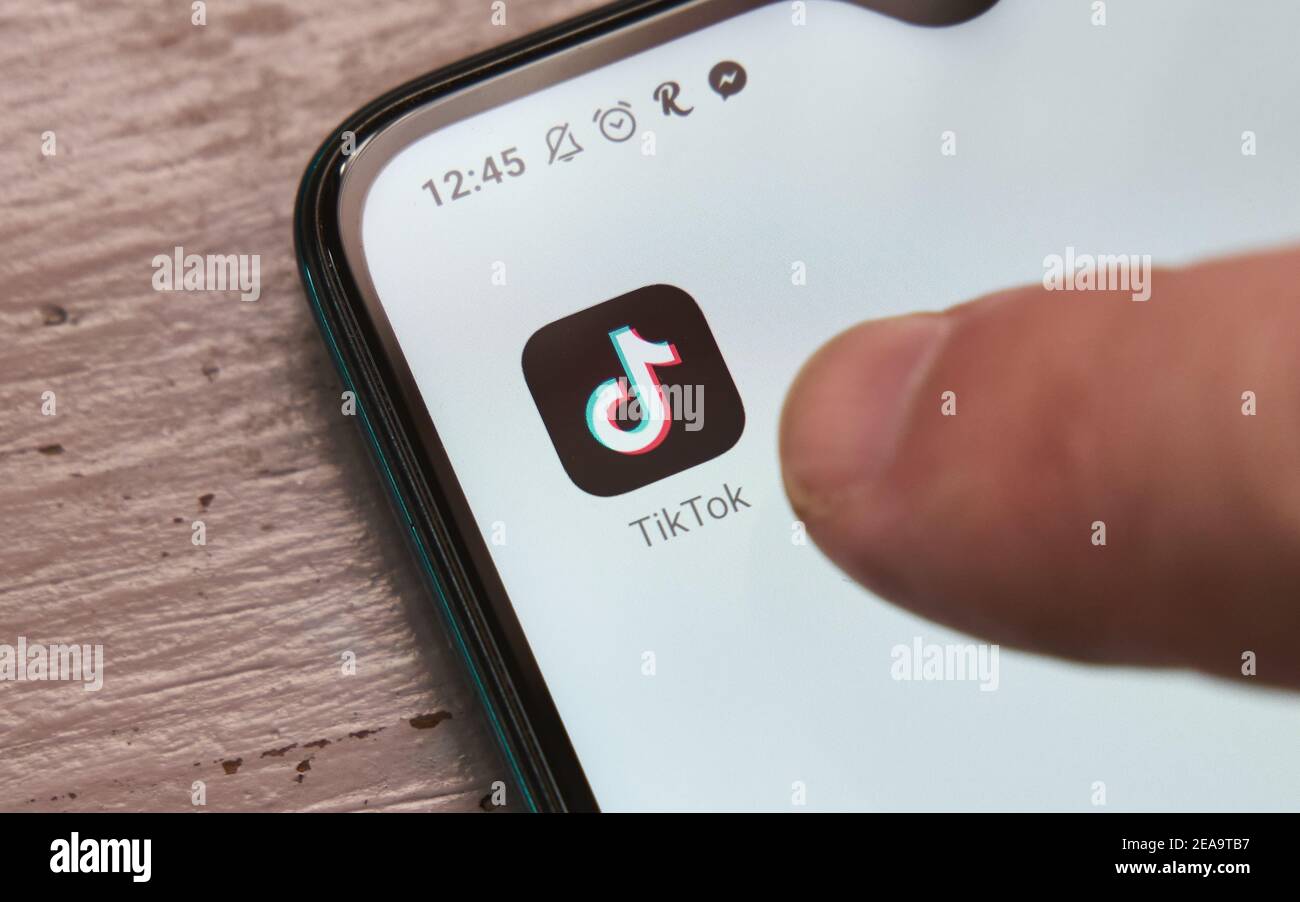 Crop anonyme Person berühren Symbol von TikTok mobile App für Video-Sharing auf dem modernen Smartphone, Mexiko, im Februar 8, 2021 Stockfoto