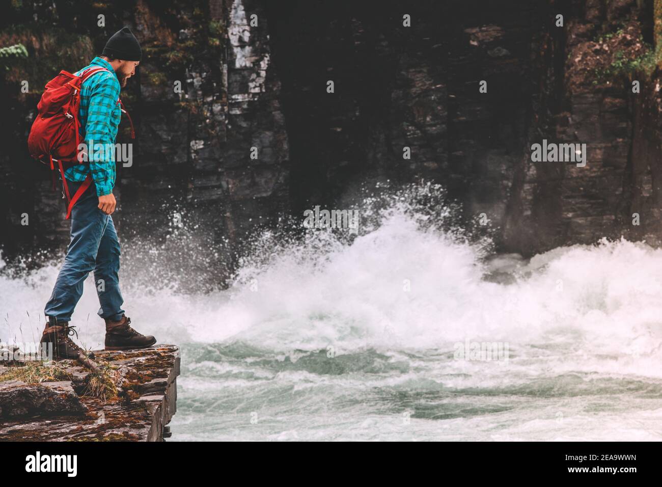 Abenteurer Mann Reisen in Schweden aktiv Wandern Lifestyle Rucksackwandern solo Wanderer stehen auf einer Klippe über dem Fluss Canyon Urlaub Reise in Wildnis Stockfoto