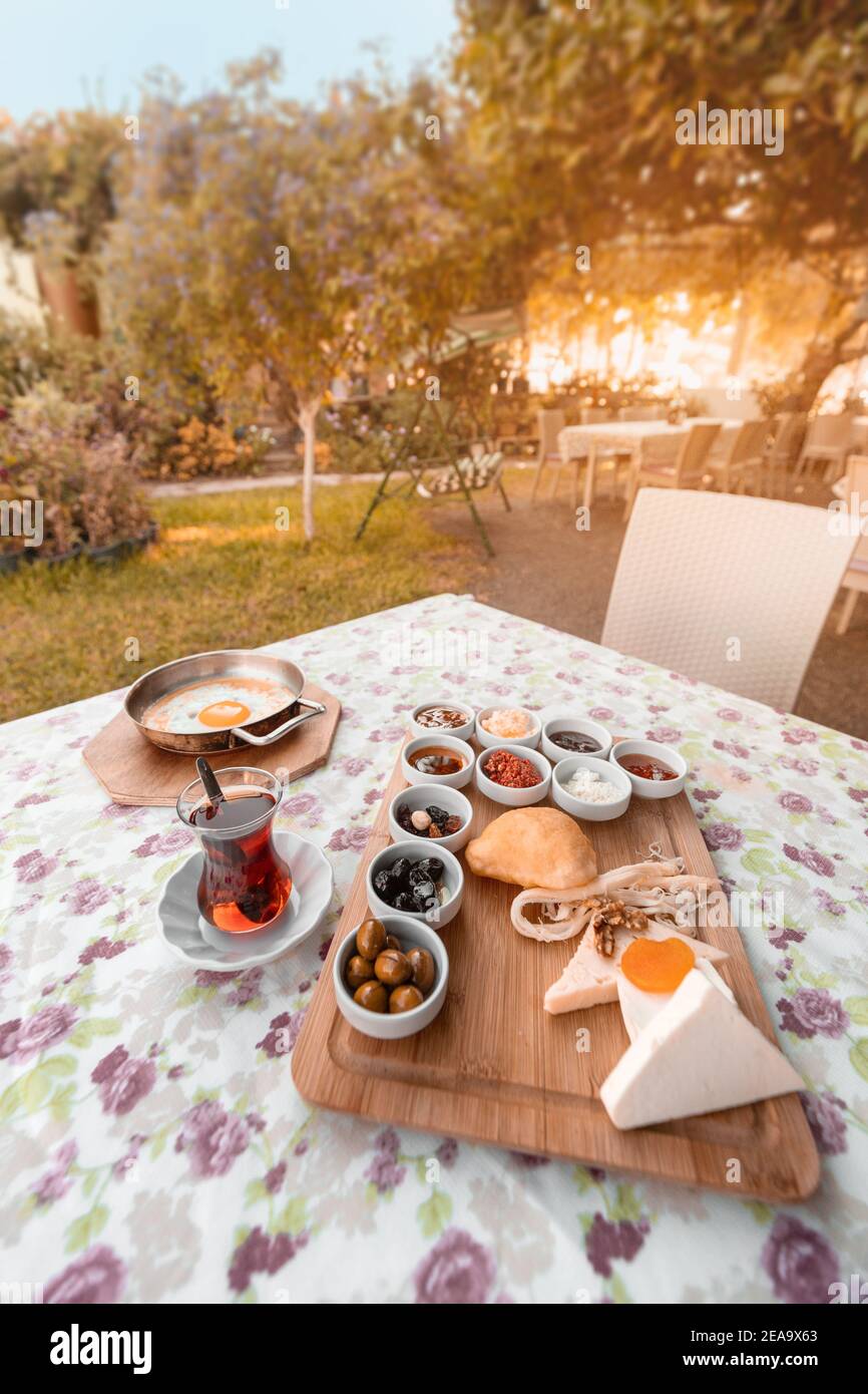 Frisch zubereitetes türkisches Frühstück mit Rührei, Tee, Gemüsesalat und einer Auswahl an Snacks und Gurken. Wunderschön gedeckten Tisch i Stockfoto