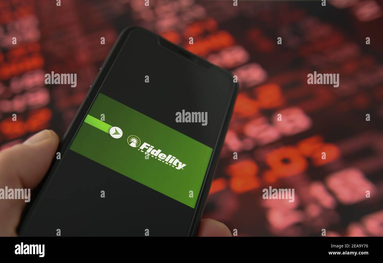 Viersen, Deutschland - Februar 6. 2021: Nahaufnahme des Handybildschirms mit Logo-Schriftzug von Fidelity Investments, Hintergrund der Börsenchart Stockfoto