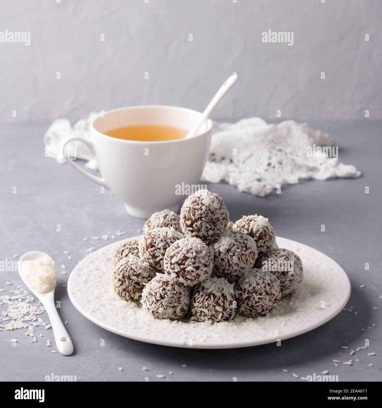 Rohdaten Süßigkeiten mit Kokosnuss auf einem grauen Hintergrund. Köstliche gesunde hausgemachte Dessert. Selektive Fokus. Quadrat Stockfoto