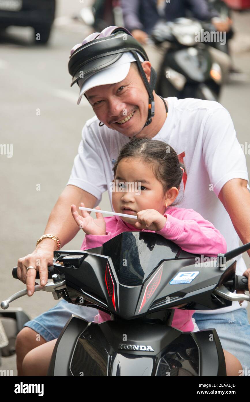 Vater mit Tochter auf Moped, Vietnam Stockfoto