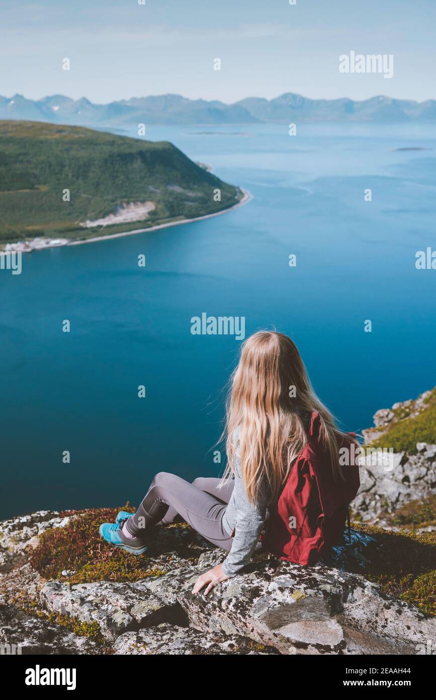 Frau, die allein auf der Klippe sitzt und die Luft betrachtet Meerblick in Norwegen Wandern solo im Freien mit Rucksack gesund Lifestyle Sommerurlaub Stockfoto