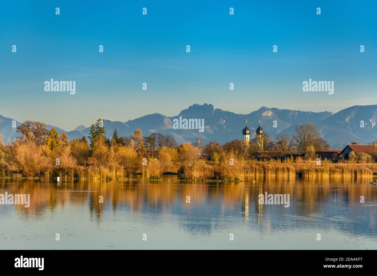 Deutschland, Bayern, Oberbayern, Kreis Rosenheim, Markt Bruckmühl, Kreis Höglinger Weiher mit Wallfahrtskirche zur Heiligen Dreifaltigkeit in Weihenlinden gegen Chiemgauer Alpen mit Kampenwand Stockfoto