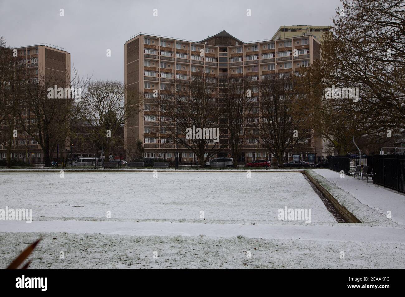 Schnee in London - Fußgänger, die in Hüte und Schals gehüllt sind, wandern im lokalen fulham Park, Hundewanderer und Kinder genießen den Schnee. 08/02/2021 Stockfoto