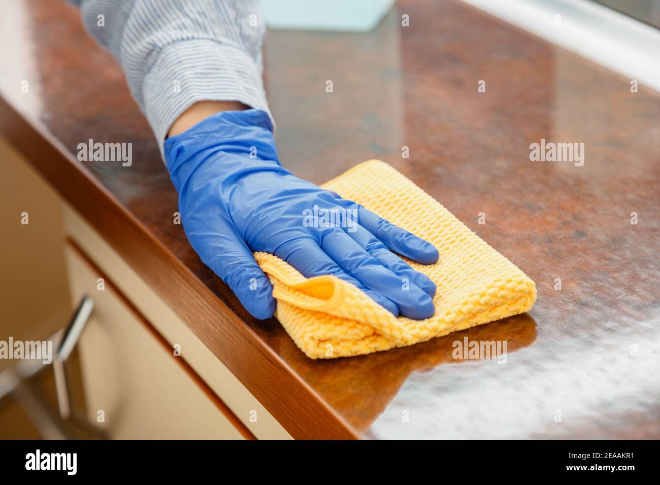 Frau wischen Tisch Arbeitsplatte in der Küche von nassen Tuch Lappen. Weibliche Charwoman Handreinigung desinfizieren Büro Heim Restaurant Oberflächen. Stockfoto