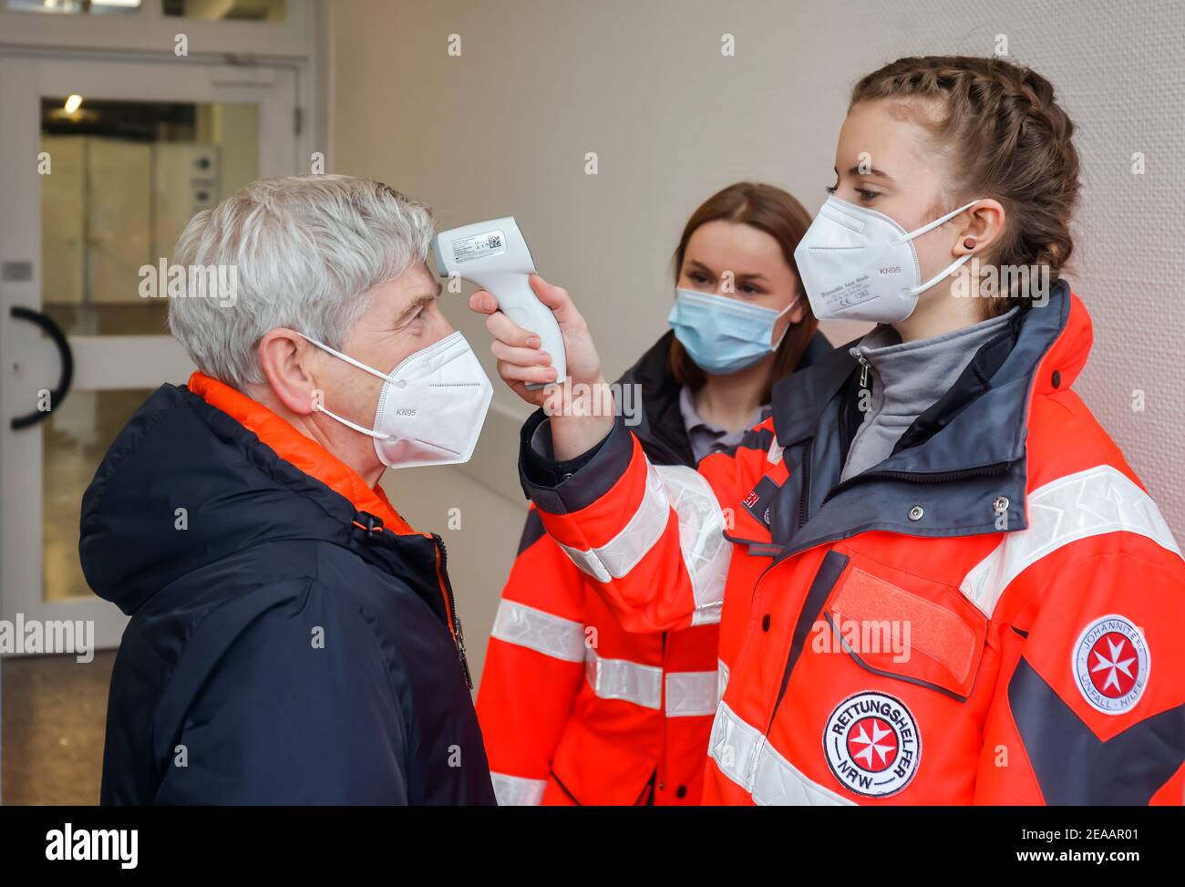 Essen, Ruhrgebiet, Nordrhein-Westfalen, Deutschland - Impfzentrum Corona Essen in den Hallen der Messe Essen sollen hier täglich mehr als 2 000 Personen geimpft werden, während eines Testlaufs messen Rettungskräfte die Temperatur einer geimpften Person (Szene mit Rentner als Extras). Stockfoto
