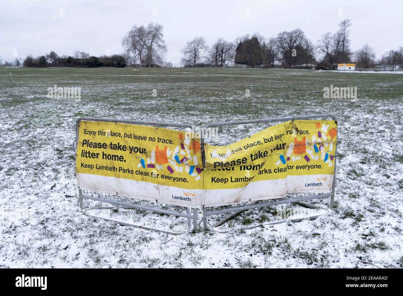 Lambeth council's Banner Warnung vor Vermüllung, eine Landschaft in einer hellen Schneedecke im Brockwell Park, einem öffentlichen Raum im Jahr SE24, Süd-London, am 8th. Februar 2021, in London, England. Stockfoto
