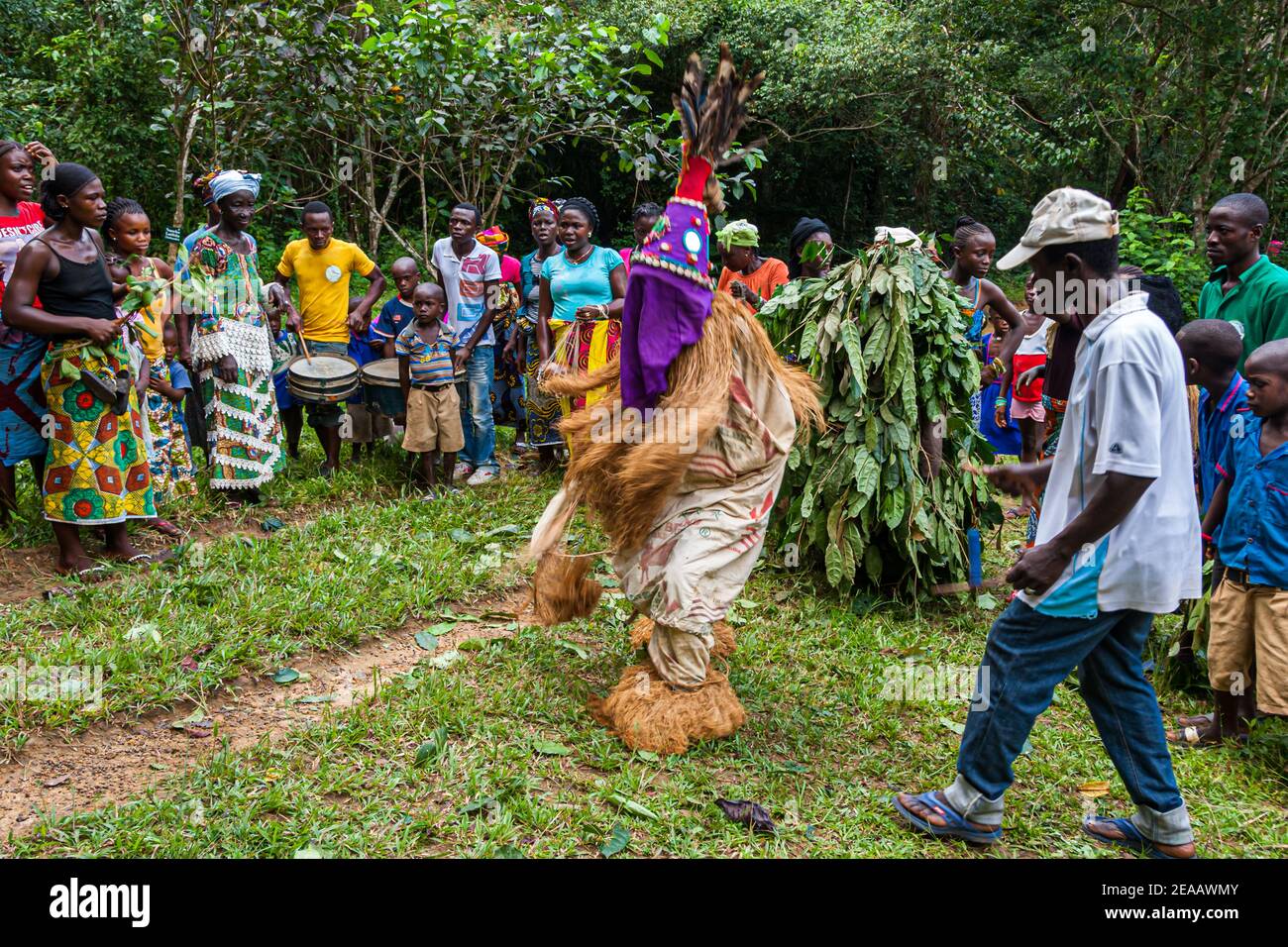 Menschen tanzen in der westlichen Region Rural, Sierra Leone. Die Menschen in Sierra Leone sind in ihren Traditionen verwurzelt. Die Balui-Tänzerin sorgt für Entspannung. Falui Scroll hat eine unterhaltsamere Funktion. Der Kopf ist mit farbigen Tüchern bedeckt und mit Kauri-Muscheln und Spiegeln verziert. Sie hat eine konische Form und hat Federn auf der Oberseite Stockfoto