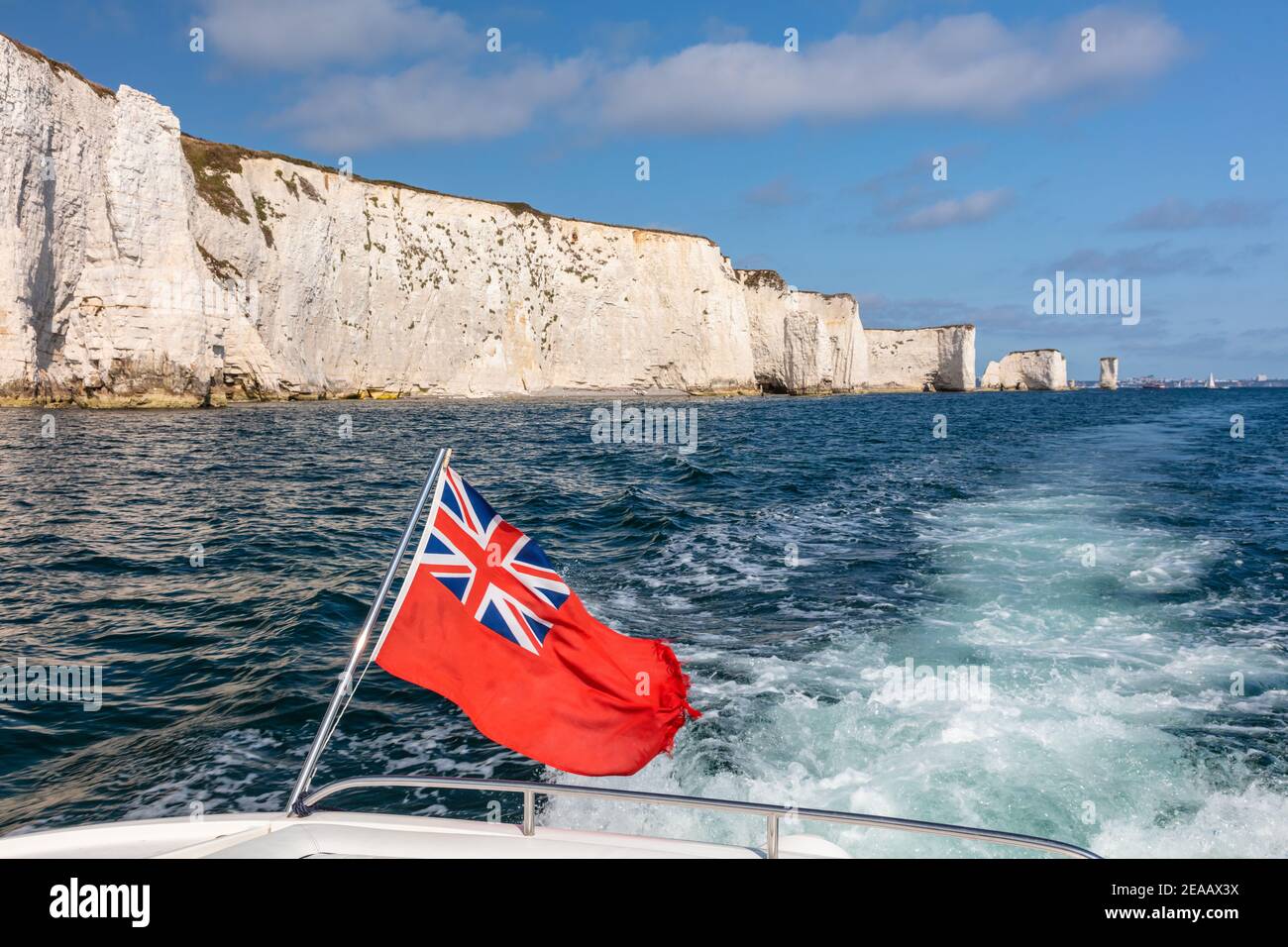 Britische rote Flagge auf dem Boot, das an Old Harry Rocks, Dorset, England vorbeifährt Stockfoto