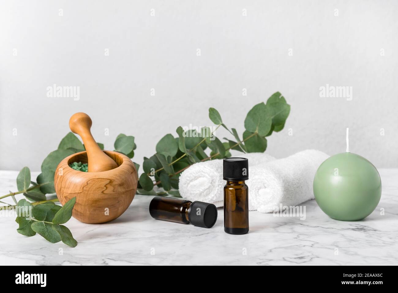 Natürliche Aromatherapie mit ätherischen Eukalyptus-Ölflaschen und aromatischen Badesalzen, Kerzen und Handtüchern auf Marmor. Zero Waste Spa, Wellness und Haut Auto Stockfoto