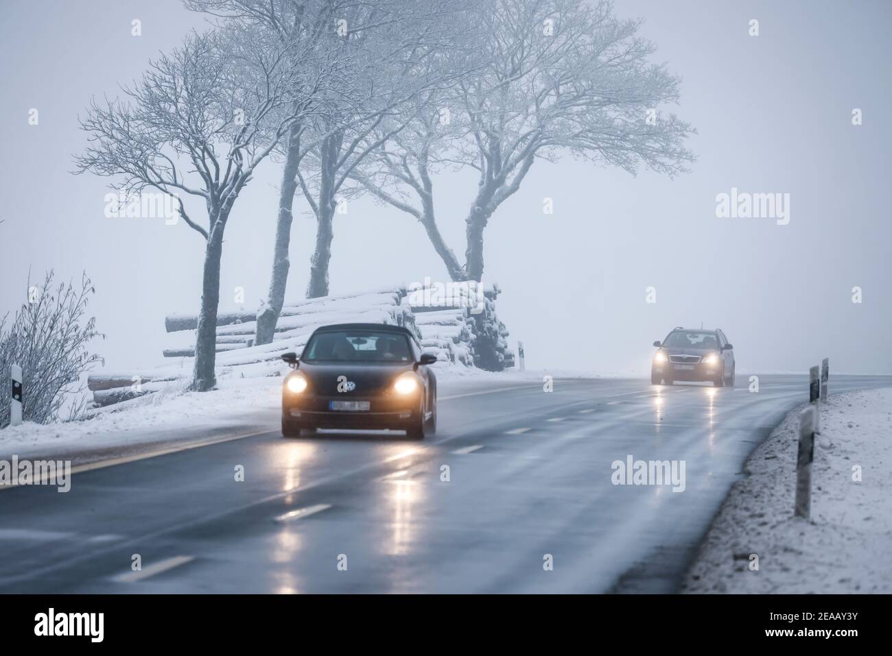12/07/2020, Winterberg, Sauerland, Nordrhein-Westfalen, Deutschland, Autos fahren auf einer Landstraße durch eine verschneite Landschaft. 00X201207D067CARO Stockfoto