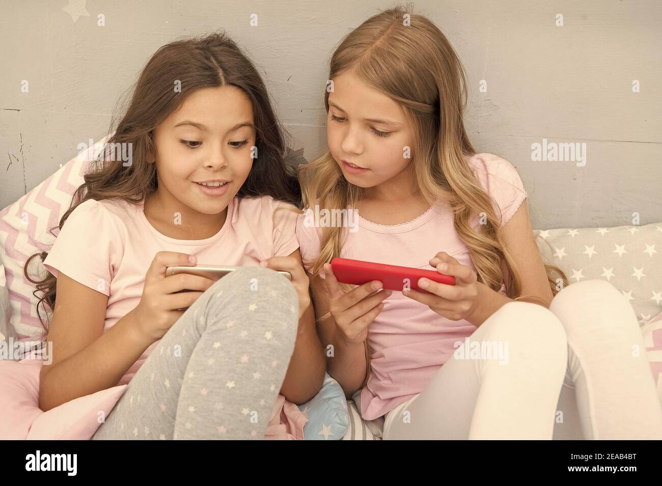 Coole sms. Kleine Mädchen lesen sms im Bett. SMS per Smartphone senden