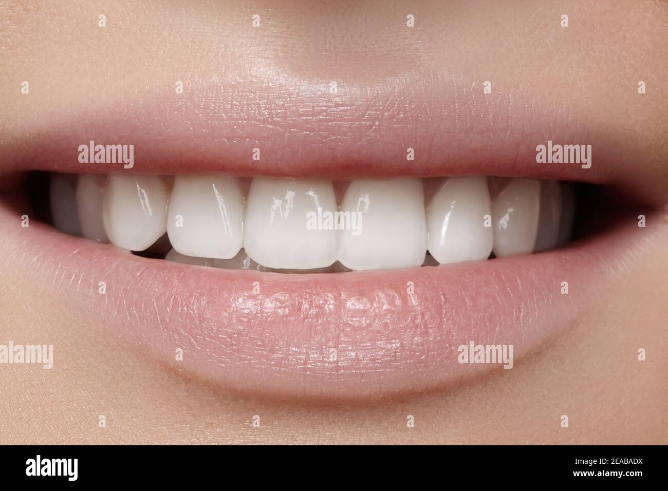 Schönes Lächeln mit Zahnaufhellung. Zahnaufnahme. Makro Nahaufnahme des perfekten weiblichen Mundes, Lippenstift-Rutin. Stockfoto