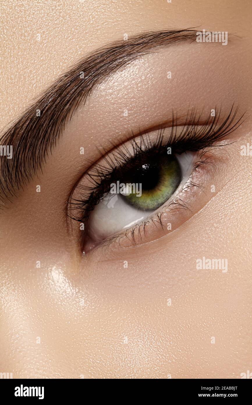 Schöne Makroaufnahme des weiblichen Auges mit klassischen sauberen Make-up. Perfekte Form von Augenbrauen, braunen Lidschatten und langen Wimpern. Kosmetik und Make-up. C Stockfoto