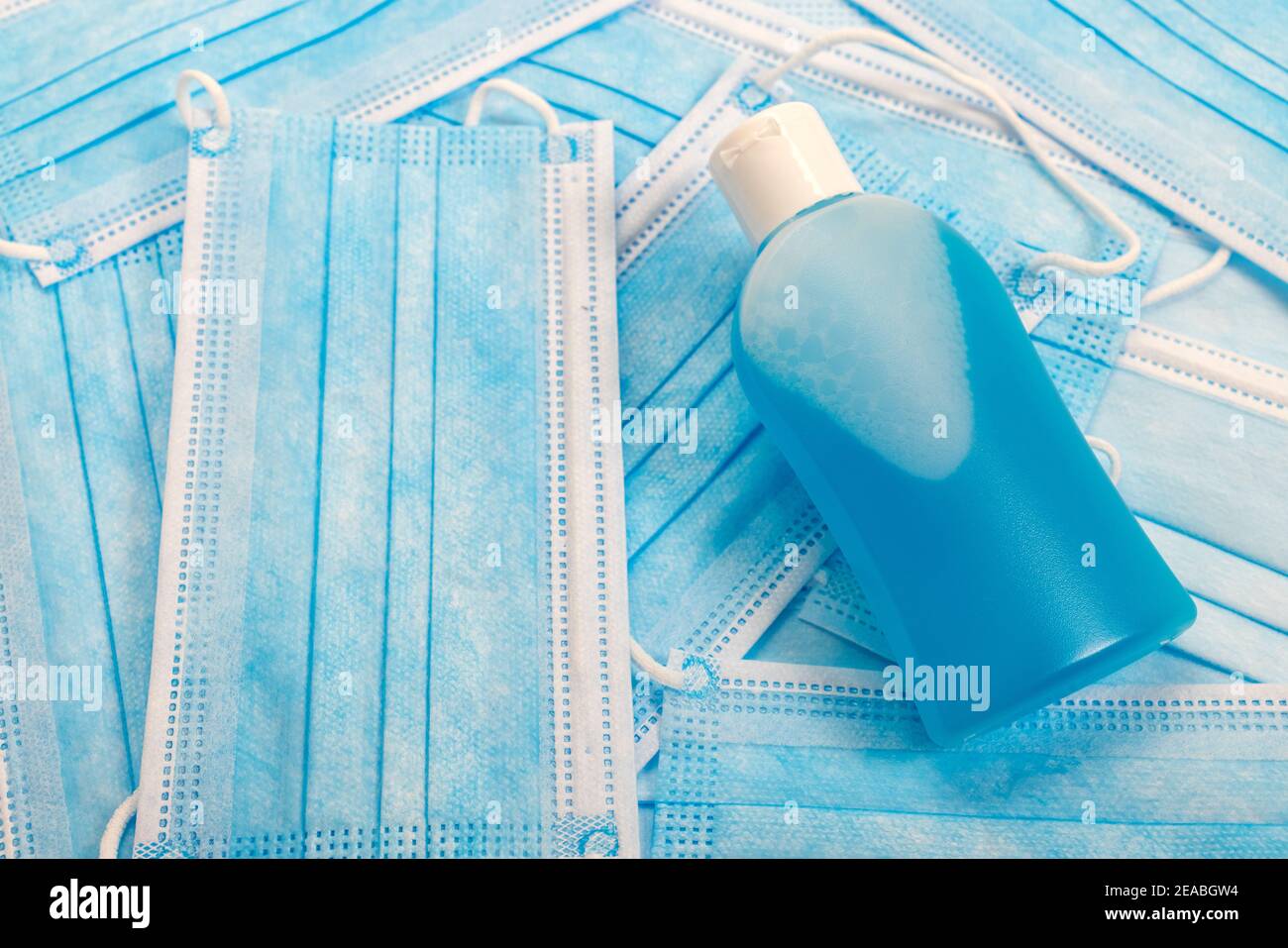 Handdesinfektionsmittel liegt auf blauen Mund Nasenschutzmasken, Symbol Foto, Coronavirus, Stockfoto