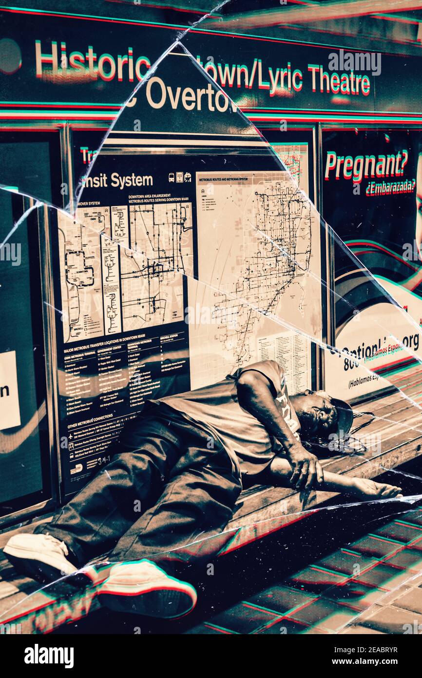 Zerbrochener Glaseffekt eines Mannes, der auf einer Bank in der historischen Overtown Metrorail Station in Downtown Miami, Florida schläft. Stockfoto