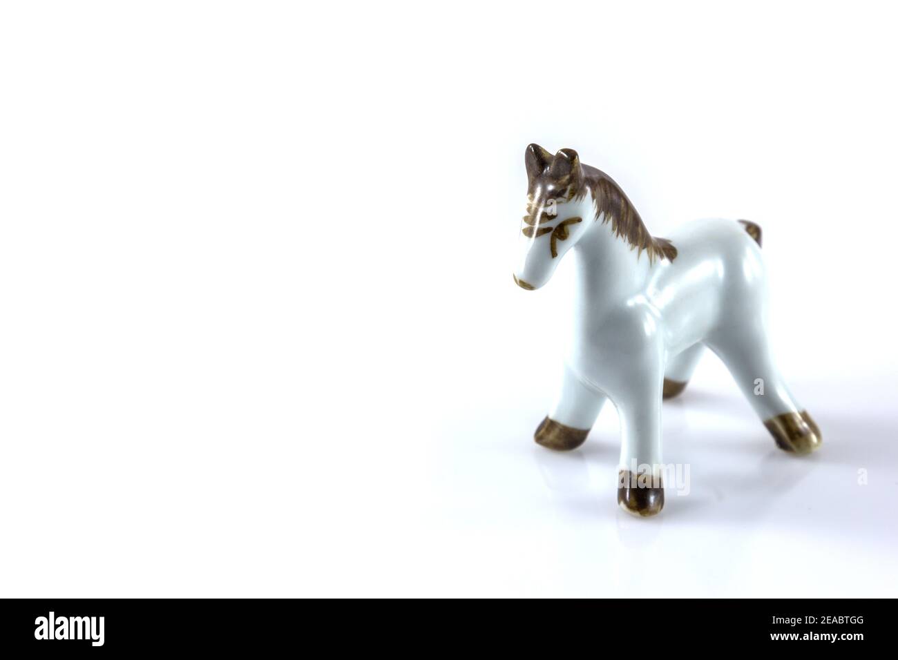Weiße Keramikfigur eines Pferdes auf weißem Hintergrund Stockfoto