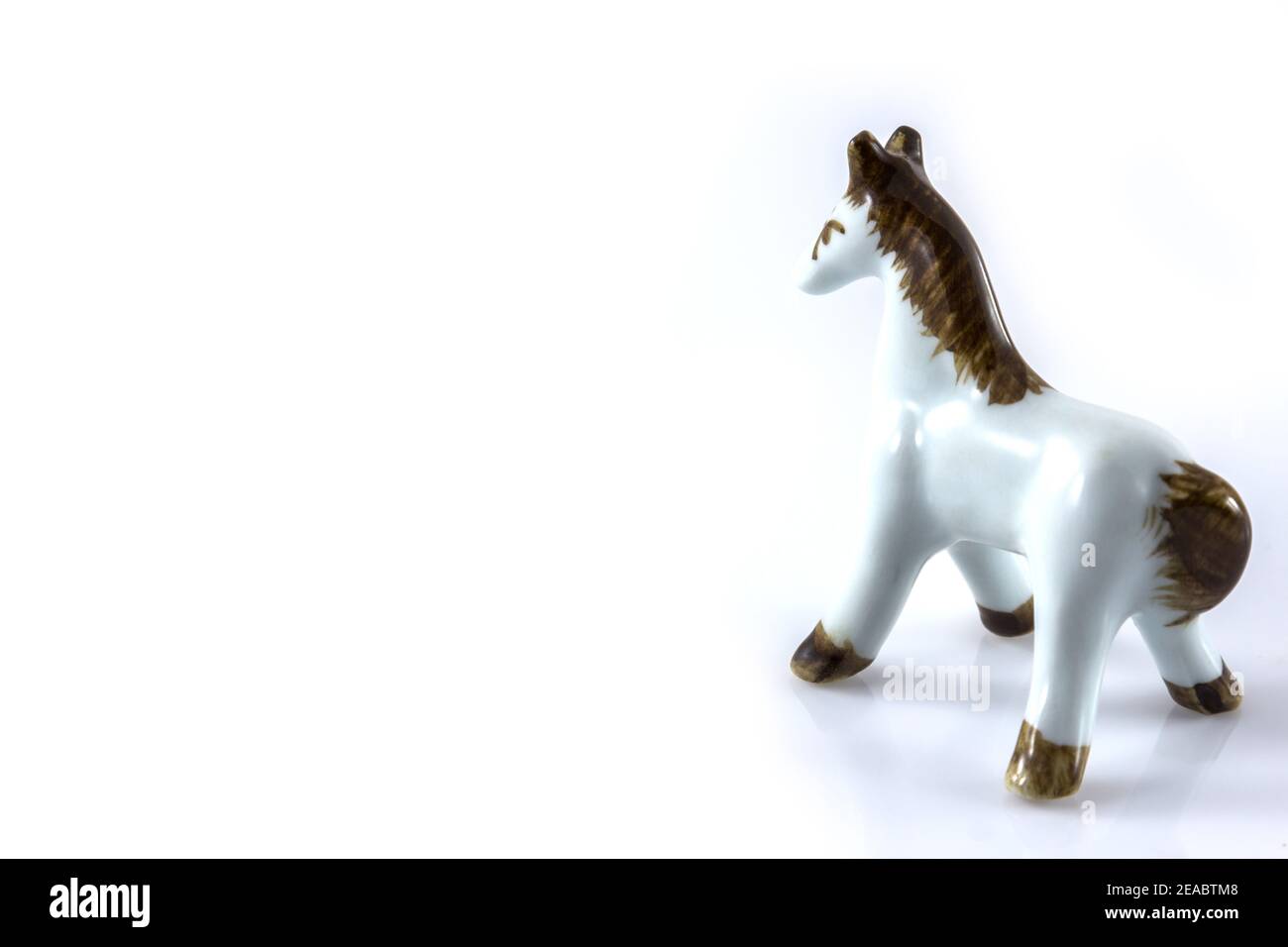 Weiße Keramikfigur eines Pferdes auf weißem Hintergrund Stockfoto