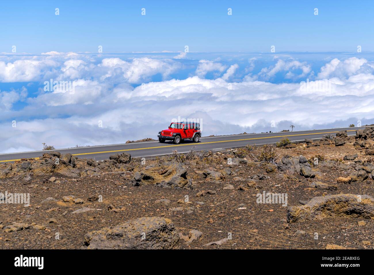 Fahren über Wolken - EIN leuchtend roter SUV fahren über den Wolken auf Haleakala Highway in der Nähe des Gipfels, bei 10.023 Fuß, im Haleakala Nationalpark. Mau Stockfoto