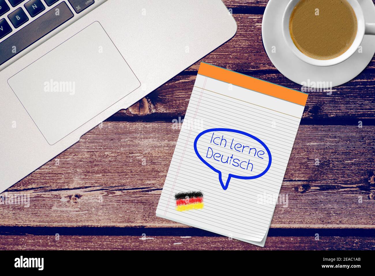 Ein Bürotisch, Schreibblock und Slogan Ich lerne Deutsch Stockfoto