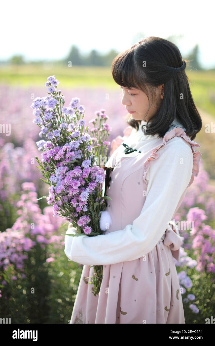 Portrait asiatische Mädchen mit lila Blumen Hintergrund Stockfoto