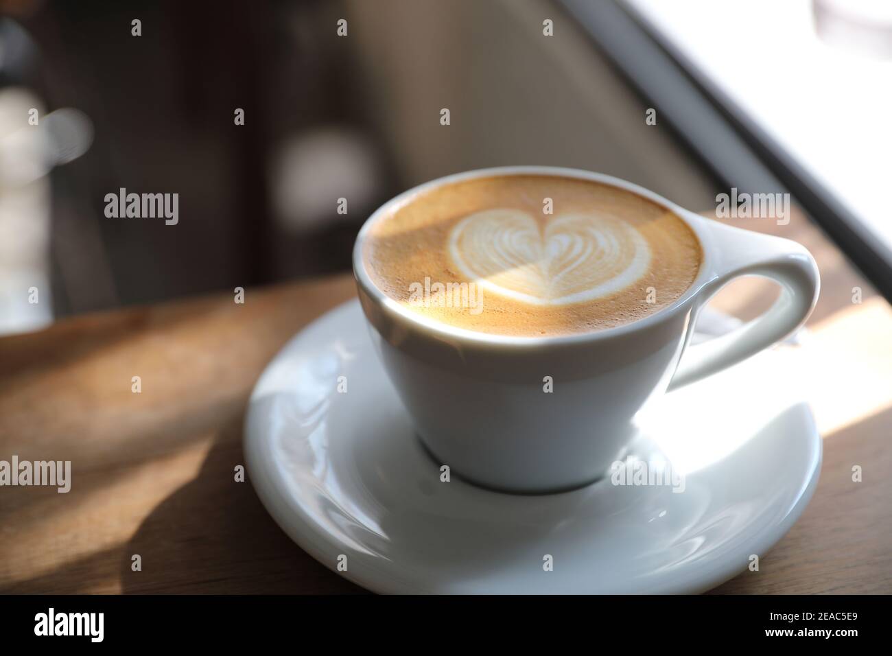 Cappuccino oder Latte Art Kaffee aus Milch auf dem Holz Tisch im Café Stockfoto