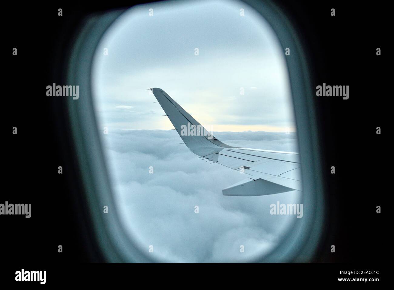 Blick aus dem Fenster eines Flugzeuges auf Wolken und Flugzeugflügel Stockfoto